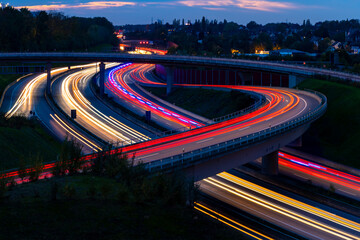 German Motorway in Bochum-Wattenschid. Streets and bridges at dusk with light traces of passing...