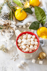 Christmas winter cozy cup with hot chocolate drink with marshmallow and gifts, tangerines on a gray stone background. Christmas food and drink concept.