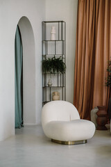 Fragment of a living room in a modern minimalist style, an arch, an armchair and a shelf