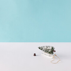 Creative layout with Christmas tree and sled on pastel blue background. Christmas tree concept. Minimal winter holiday idea.