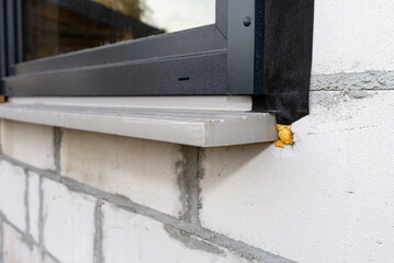 Warm installation of a three-layer window with a polystyrene window sill, view from the outside.