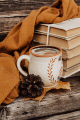 Hot spicy coffee and pile of old books on wooden background