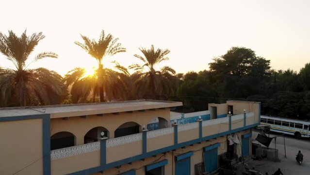 Aerial shot of a country side house in Khairpur Sindh with setting sun in the background.