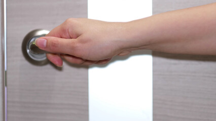 side view of a woman enters a bright room, takes the first step. Close-up of a female hand opening...