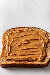 Open sandwich from slice of wholegrain bread with peanut nut butter