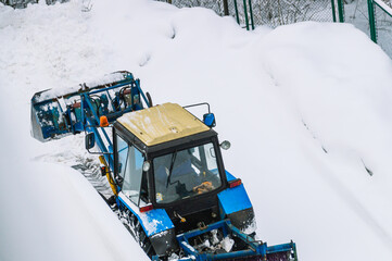Tractor for snow removal with a blade. A snowplow tractor removes snow from the road after a...