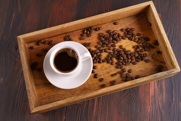 Cup of black coffee, coffee beans in wooden box,flat lay.