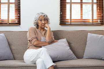 Asian elderly senior female at nursing home living room feeling sad missing unhappy thoughtful in mental health care in older people.