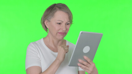 Old Woman Reacting to Loss on Tablet on Green Background