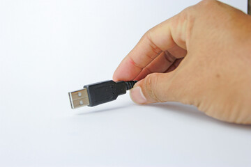 hand holding usb port with black cable.