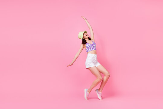 Full body photo of pretty excited girl enjoy partying dancing good mood isolated on pink color background