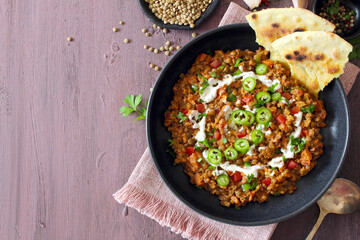 Lentil with vegetables served with sream and naan bread. Top view. Vegetarian and vegan food.