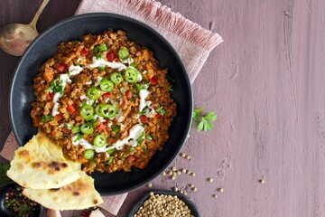 Lentil with vegetables served with sream and naan bread. Top view. Vegetarian and vegan food.