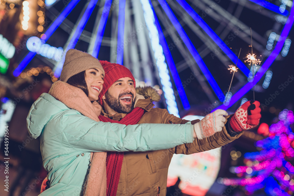 Poster Portrait of two cheerful partners hands hold bengal lights stick have fun garland tree holly jolly outside