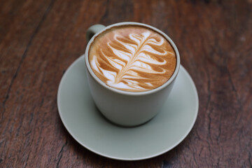 hot cappuccino with latte art on wood background