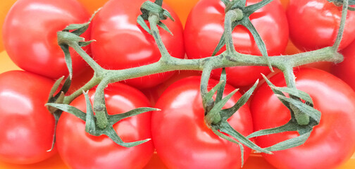 background, a brunch of tomatoes with a shiny surface close up