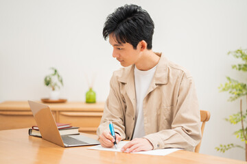 パソコンを見ながら学習する日本人男性 - obrazy, fototapety, plakaty