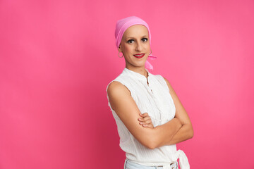portrait of a woman suffering from breast cancer with a pink handkerchief on a pink background