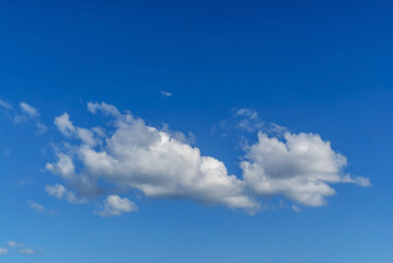 White clouds in a blue sky of different shapes.