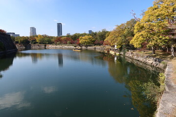 Fototapeta na wymiar A Japanese castle : the moat and stone wall of Osaka-jyo Castle and an excursion boat in Osaka City 日本のお城：大阪市の大阪城の堀と石垣と観光ボート