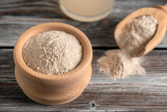 Psyllium husk in a wooden bowl on a wooden old table. Side view, selective focus. Gluten free superfood.