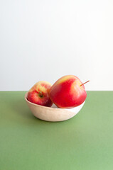 Bright red sweet apples on white and green background with copyspace for your text.