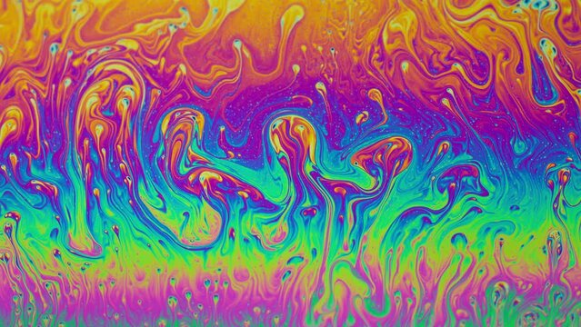 Fluid soap bubble psychedelic colorful abstract art. Surreal patterns with rainbows and waves of color in motion.