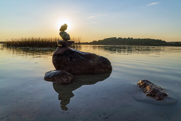 A stone pyramid at sunset in the lake . Leningrad region. Vsevolozhsk.