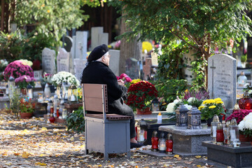 Polski cmentarz w czasie święta zmarłych odwiedzają starsi ludzie. - obrazy, fototapety, plakaty