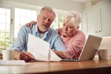 Worried Retired Senior Couple Looking At Bills At Home Concerned About Cost Of Living