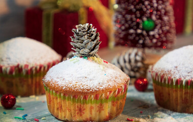 Christmas delicious cupcake with cone on the top. Christmas tree and muffins on the background 