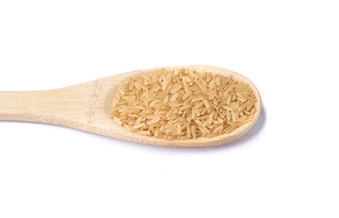 Raw brown whole rice in a spoon isolated over white background