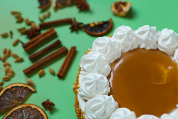Caramel cake with nuts and caramel sauce glaze. whipped cream with cinnamon. rounded tart or pie