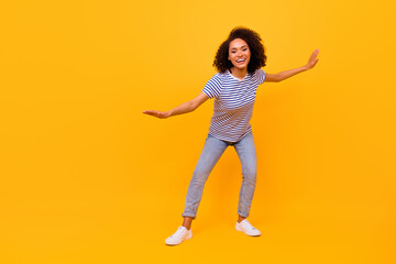 Fototapeta na wymiar Full body photo of charming cheerful girl hands make moves dancing isolated on yellow color background