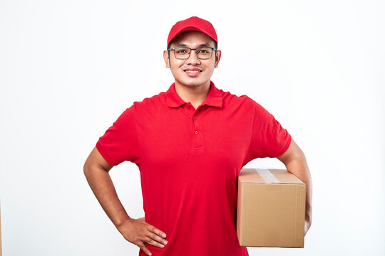 Cheerful asian man in red cap and t-shirt, holding parcel box. Courier pick-up package from client