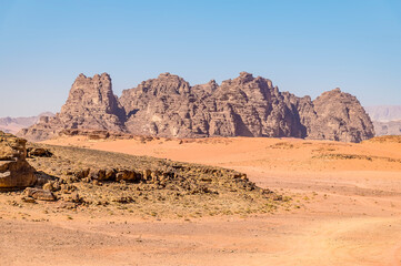 Fototapeta na wymiar A view of rocky outcrops in the desert landscape in Wadi Rum, Jordan in summertime