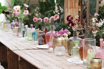 Beautiful decoration with flowers and colorful glass vases