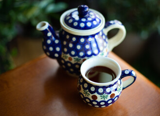 Black tea and beautiful teapot and cup on board