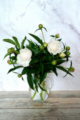 A view of a bouquet of white peonies standing in a vase on the window. Concept background, flowers, holiday