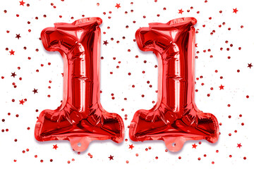 The number of the balloon made of red foil, the number eleven on a white background with sequins....