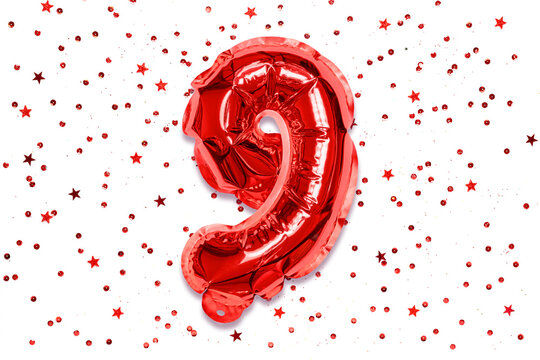The number of the balloon made of red foil, the number nine on a white background with sequins. Birthday greeting card with inscription 9. Numerical digit, Celebration event, template.