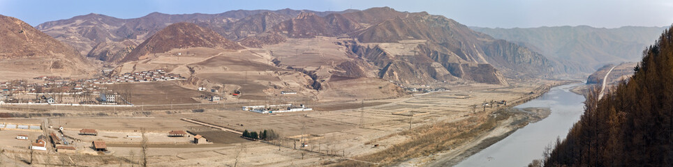 TUMEN, JILIN PROVINCE, CHINA: panoramic view of Namyang school and outskirts and farming village, in North Korea, across the Tumen river, from Chinese side, Yanbian Korean Autonomous Prefecture