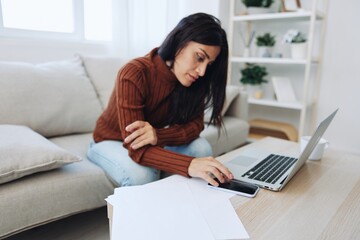 Naklejka premium Sad freelance woman typing on laptop and working online from home