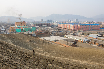 TUMEN, JILIN PROVINCE, CHINA - April 2008: peasant working in field and general view of Tumen city,...