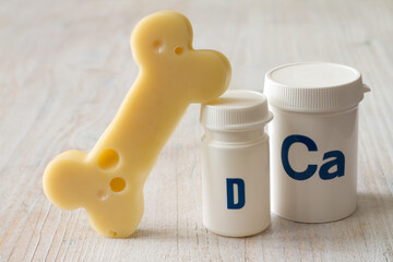 Bone shaped cheese and dietary supplements with calcium and vitamin D, strong and healthy bones concept