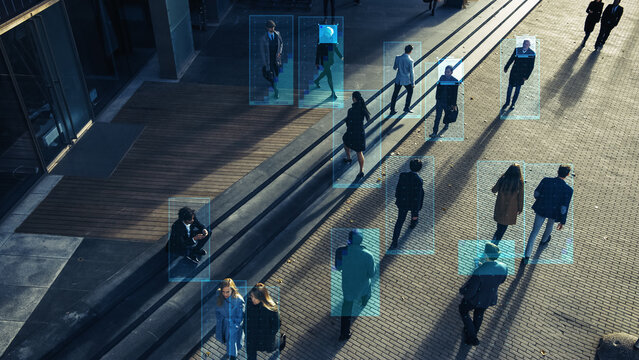 Elevated Security Camera Surveillance Footage Of A Crowd Of People Walking On Busy Urban City Streets. CCTV AI Facial Recognition Big Data Analysis Interface Scanning, Showing Personal Information.