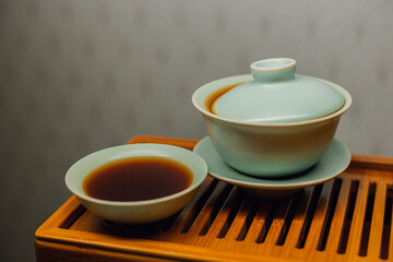 Brewing Chinese tea in ceramic gaiwan during the tea ceremony close-up. Gaiwan and other tea tools for the ceremony. 
