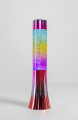 A retro iconic rainbow coloured lava lamp isolated on a white background. Vibrant colourful kids...