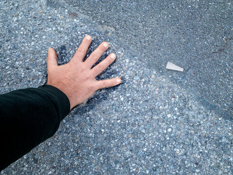 Klimaaktivist mit Hand auf Straße geklebt