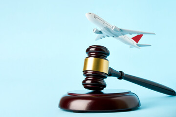 Wooden gavel and toy plane blue background